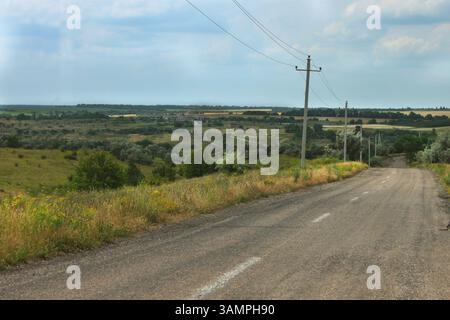 Ein majestätischer Panoramablick auf die weiten Weiten von der Spitze des Hügels, die Straße geht in die Ferne, Stockfoto