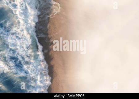Aus der Vogelperspektive sehen Sie große Wellen, die auf einen unberührten weißen Sandstrand stürzen, Kapstadt, Westkap, Südafrika. Stockfoto