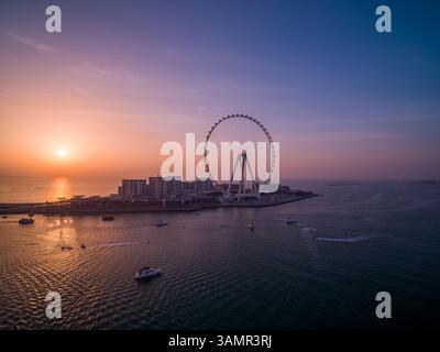 Aus der Vogelperspektive auf Ain Dubai, das größte Riesenrad der Welt bei Sonnenuntergang mit vielen Motorbooten, die den Persischen Golf, Dubai, Vereinigte Arabische Emirate segeln. Stockfoto