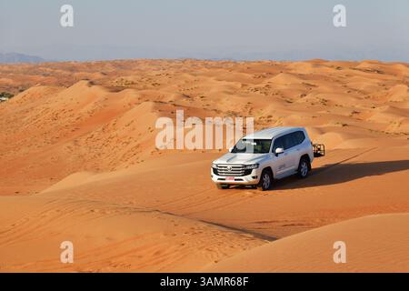 RUB Al Khali Wüste, Sultanat Oman - 5. April 2025: Geländewagen in der Wüste Wahiba Sands bei Sonnenaufgang, Arabische Halbinsel Stockfoto