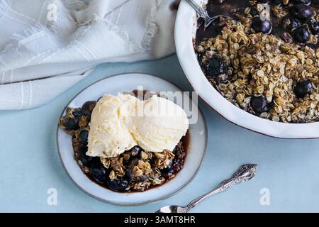 Hausgemachte Kirschknusprig serviert mit französischem Vanilleeis. Ansicht der Tischaufsicht. Flach. Stockfoto