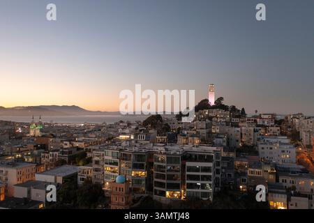 Blick aus der Vogelperspektive auf den Sonnenuntergang der Stadt mit Coit Tower und der Skyline über der Bucht, North Waterfront, Kalifornien, USA. Stockfoto