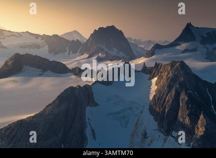 Luftaufnahme des dramatischen Sonnenuntergangs über schneebedeckten Bergen und Gletschern im Juneau Ice Field, Alaska, USA. Stockfoto
