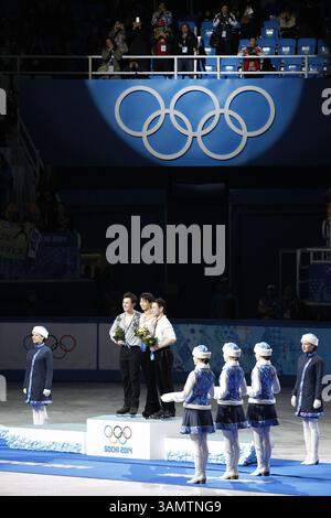 14. Februar 2014 - Sotschi, Russland - Silbermedaillengewinner Patrick Chan aus Kanada, links, Goldmedaillengewinner Yuzuru Hanu aus Japan, Mitte und Bronzemedaillengewinner Denis Ten aus Kasachstan stehen während der Blumenzeremonie bei den Eiskunstlauf-Männern bei den Olympischen Winterspielen 2014 in Sotschi im Eislaufpalast auf dem Podium. (Bild: © David McIntyre/ZUMAPRESS.com) Stockfoto