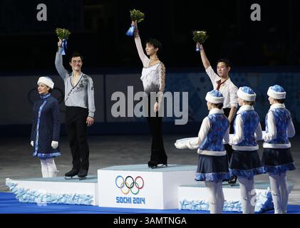 14. Februar 2014 - Sotschi, Russland - Silbermedaillengewinner Patrick Chan aus Kanada, links, Goldmedaillengewinner Yuzuru Hanu aus Japan, Mitte und Bronzemedaillengewinner Denis Ten aus Kasachstan stehen während der Blumenzeremonie bei den Eiskunstlauf-Männern bei den Olympischen Winterspielen 2014 in Sotschi im Eislaufpalast auf dem Podium. (Bild: © David McIntyre/ZUMAPRESS.com) Stockfoto