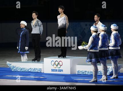 14. Februar 2014 - Sotschi, Russland - Silbermedaillengewinner Patrick Chan aus Kanada, links, Goldmedaillengewinner Yuzuru Hanu aus Japan, Mitte und Bronzemedaillengewinner Denis Ten aus Kasachstan stehen während der Blumenzeremonie bei den Eiskunstlauf-Männern bei den Olympischen Winterspielen 2014 in Sotschi im Eislaufpalast auf dem Podium. (Bild: © David McIntyre/ZUMAPRESS.com) Stockfoto