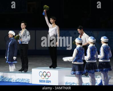 14. Februar 2014 - Sotschi, Russland - Silbermedaillengewinner Patrick Chan aus Kanada, links, Goldmedaillengewinner Yuzuru Hanu aus Japan, Mitte und Bronzemedaillengewinner Denis Ten aus Kasachstan stehen während der Blumenzeremonie bei den Eiskunstlauf-Männern bei den Olympischen Winterspielen 2014 in Sotschi im Eislaufpalast auf dem Podium. (Bild: © David McIntyre/ZUMAPRESS.com) Stockfoto