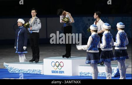 14. Februar 2014 - Sotschi, Russland - Silbermedaillengewinner Patrick Chan aus Kanada, links, Goldmedaillengewinner Yuzuru Hanu aus Japan, Mitte und Bronzemedaillengewinner Denis Ten aus Kasachstan stehen während der Blumenzeremonie bei den Eiskunstlauf-Männern bei den Olympischen Winterspielen 2014 in Sotschi im Eislaufpalast auf dem Podium. (Bild: © David McIntyre/ZUMAPRESS.com) Stockfoto