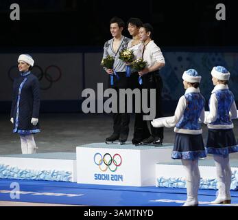 14. Februar 2014 - Sotschi, Russland - Silbermedaillengewinner Patrick Chan aus Kanada, links, Goldmedaillengewinner Yuzuru Hanu aus Japan, Mitte und Bronzemedaillengewinner Denis Ten aus Kasachstan stehen während der Blumenzeremonie bei den Eiskunstlauf-Männern bei den Olympischen Winterspielen 2014 in Sotschi im Eislaufpalast auf dem Podium. (Bild: © David McIntyre/ZUMAPRESS.com) Stockfoto