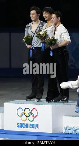 14. Februar 2014 - Sotschi, Russland - Silbermedaillengewinner Patrick Chan aus Kanada, links, Goldmedaillengewinner Yuzuru Hanu aus Japan, Mitte und Bronzemedaillengewinner Denis Ten aus Kasachstan stehen während der Blumenzeremonie bei den Eiskunstlauf-Männern bei den Olympischen Winterspielen 2014 in Sotschi im Eislaufpalast auf dem Podium. (Bild: © David McIntyre/ZUMAPRESS.com) Stockfoto