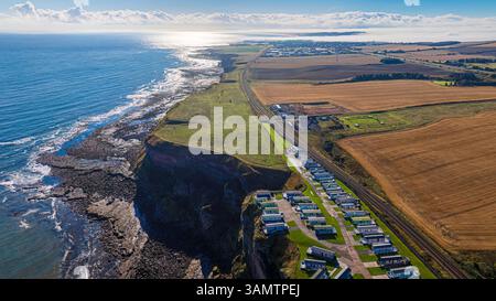 Blick aus der Vogelperspektive auf die wunderschöne Küste mit Wohnwagen und Klippen mit Blick auf das Meer, Berwick-upon-Tweed, Großbritannien. Stockfoto