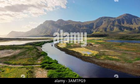 Blick aus der Vogelperspektive auf Fluss, Berge, Boot und Ponton, Overstrand NU, Westkap, Südafrika. Stockfoto