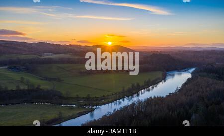 Aus der Vogelperspektive auf den ruhigen Sonnenuntergang über dem Fluss Tay und üppigen Wald in Dunkeld, Perthshire, Schottland. Stockfoto