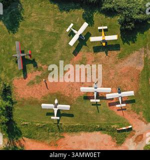 Luftaufnahme einer Reihe ultraleichter Flugzeuge, die auf einem privaten Flugplatz in Senago, Lombardei, Italien parkten. Stockfoto