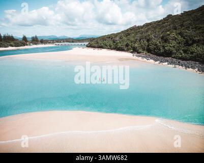 Aus der Vogelperspektive auf den Tallebudgera Creek mit einem Paar, die im Wasser spazieren gehen, Gold Coast, Queensland, Australien. Stockfoto