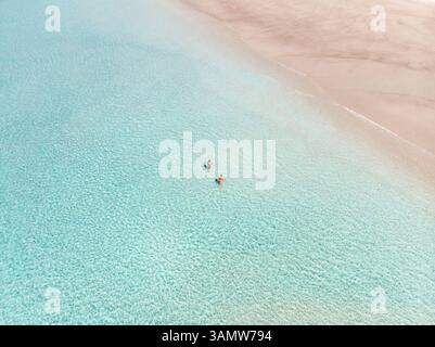 Aus der Vogelperspektive auf den Tallebudgera Creek mit einem Paar, das im Wasser spaziert, Gold Coast, Australien. Stockfoto
