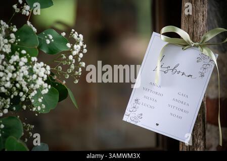 Eine schön gestaltete Sitzkarte für Gäste an einem Hochzeitsort in Lissabon. Blumen und Grün unterstreichen das elegante Ambiente. Stockfoto