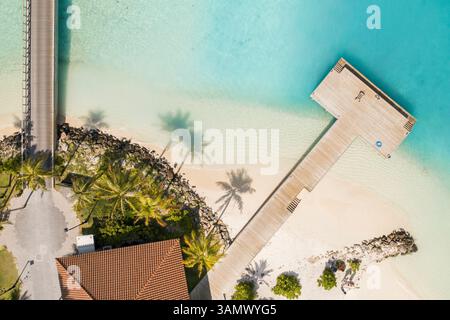 Von oben nach unten auf die tropische Insel mit White Sand Beach, Jet Ski, Jetty und Bridge, im South Male Atoll auf den Malediven. Stockfoto