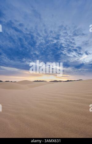 Blick aus der Vogelperspektive auf wunderschöne Sanddünen unter einem ruhigen Sonnenuntergangshimmel mit Wolken, Ciudad Juarez, Mexiko. Stockfoto