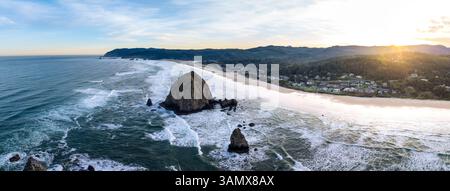 Blick aus der Vogelperspektive auf den wunderschönen Cannon Beach mit dem berühmten Haystack Rock und dem ruhigen Pazifik bei Sonnenaufgang, Cannon Beach, Oregon, USA. Stockfoto