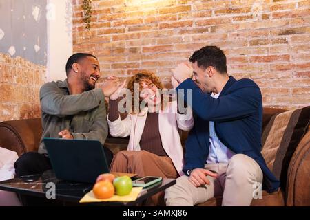 Glückliches Geschäftsteam feiert Erfolge im Coworking-Bereich Stockfoto