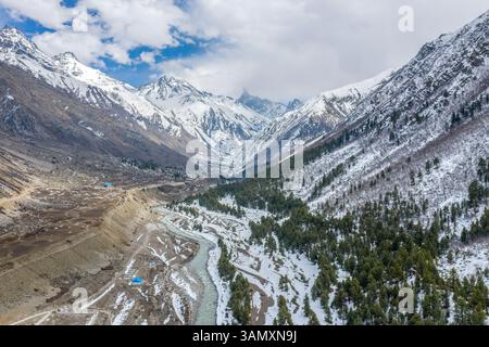 Aus der Vogelperspektive auf schneebedeckte Berge, Tal, Fluss und Bäume im ruhigen Sangla, Himachal Pradesh, Indien. Stockfoto