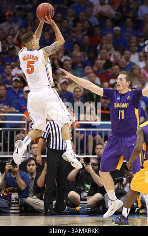 20. März 2014: Orlando, FL, USA – der Garde der Florida Gators Scottie Wilbekin (5) schießt am Donnerstag, den 20. März 2014, einen drei Zeiger über den Vorläufer der Albany Great Danes Luke Devlin (11). (Kreditbild: © Stephen M. Dowell/MCT/ZUMAPRESS.com) Stockfoto