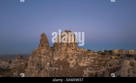 Blick aus der Vogelperspektive auf das Schloss Uchisar, umgeben von einzigartigen Felsformationen bei Sonnenuntergang, Uchisar, Türkei. Stockfoto