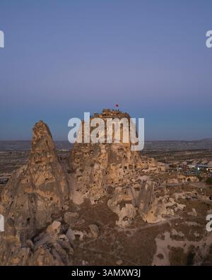 Blick aus der Vogelperspektive auf die Burg uchisar, umgeben von atemberaubenden Felsformationen und einem malerischen Tal bei Sonnenuntergang, Uchisar, Türkei. Stockfoto