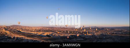 Aus der Vogelperspektive sehen Sie bunte Heißluftballons, die bei Sonnenaufgang über einer wunderschönen Landschaft schweben, Goreme, Türkei. Stockfoto