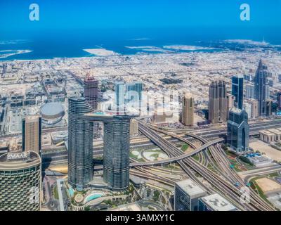 DUBAI, VAE. Blick aus der Vogelperspektive über Wolkenkratzer und die geschäftige Kreuzung vom Burj Khalifa. Stadtbild, futuristische Stadt, Skyline der Stadt. Stockfoto