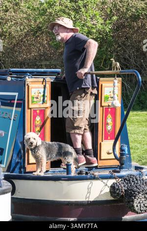 Rund um den Kennet und Avon Canal bei Seend Wiltshire UK Senior man mit seinem Hund auf einer engen Schiffsschleuse Stockfoto