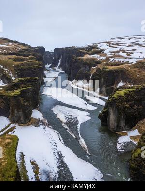 Blick aus der Vogelperspektive auf den Fjardargljufur Canyon mit Fluss im Winter, Island. Stockfoto