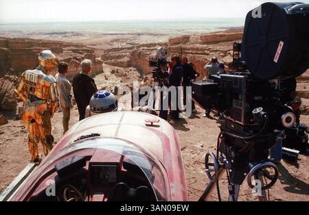 ERSCHEINUNGSDATUM: 25. Mai 1977. TITEL: Star Wars: Episode IV – A New Hope. STUDIO: Lucasfilm. DIREKTOR: George Lucas. HANDLUNG: Luke Skywalker schließt sich mit einem Jedi-Ritter, einem übermütigen Piloten, einem wookiee und zwei Droiden zusammen, um das Universum vor der weltzerstörenden Kampfstation des Imperiums zu retten, während er gleichzeitig versucht, Prinzessin Leia vor dem bösen Darth Vader zu retten. IM BILD: Anthony Daniels als C-3PO, Mark Hamill als Luke Skywalker, Alec Guinness als Obi-Wan Kenobi und Kenny Baker als R2-D2 werden 1976 in Tunesien gedreht und gedreht. Stockfoto