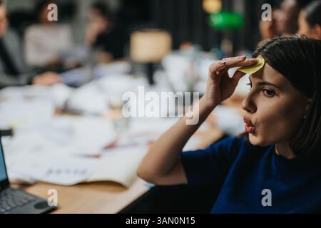 Zielgerichtete Geschäftsfrau, die Ideen während einer Besprechung am späten Abend im Büro erarbeitet Stockfoto