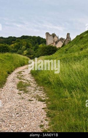 Les Andelys, Frankreich - 23. Juni 2021: Schotterwanderweg, der an einem bewölkten Sommertag in Frankreich zu den Ruinen der Burg Chateau Gaillard führt. Stockfoto