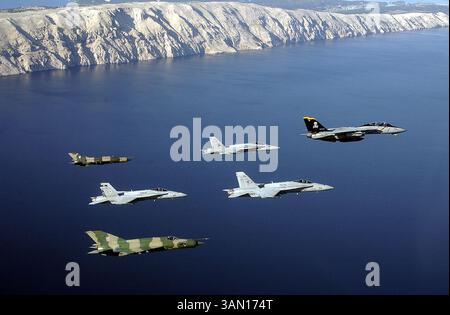 29. OKT. 2002 - USA - KRT STAND ALONE WORLD NEWS PHOTO SLUGGED: NAVY-CROTIA KRT PHOTO BY CPT. DANA POTTS/US NAVY NACHRICHTENFOTO (Oktober 30) zwei kroatische MiG-21-Kämpfer in Tarnfarben nehmen am 29. Oktober 2002 an einem Flug von drei F/A-18-Kämpfern der US Navy in grauer Farbe und einer F-14 Teil, rechts, als sie Pula, Kroatien, überfliegen. (USN) NC KD BL 2002 (Horiz) (gsb) (Kreditbild: © US Navy News/mct/ZUMAPRESS.com) Stockfoto