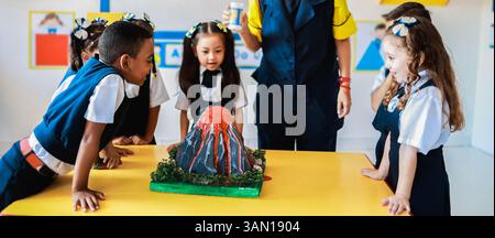 Schule, Gruppe von Kindern im Wissenschaftsunterricht Erfahren Sie mehr über Vulkane im Kindergartenzimmer. Bildungskonzept Stockfoto