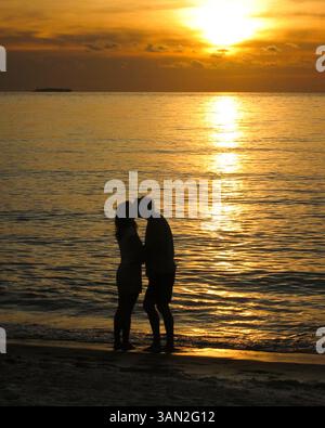 3. April 2010 - Boca Raton, Florida, USA - Junges Paar küsst sich am Strand von Boca Raton, während die Sonne über dem Atlantischen Ozean aufgeht. (Kreditbild: © Arnold Drapkin/ZUMA Press) (Kreditbild: © Arnold Drapkin/ZUMA Press) Stockfoto