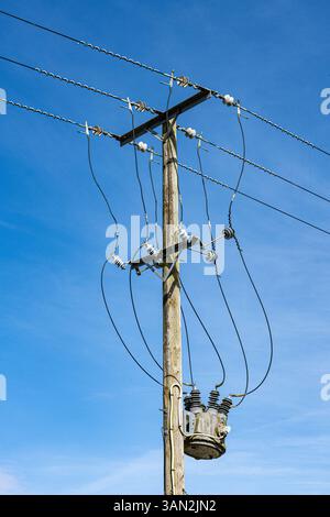 Eine Freilandstromleitung an einem Holzmast des Stromnetzes. Alresford, Hampshire, Großbritannien Stockfoto