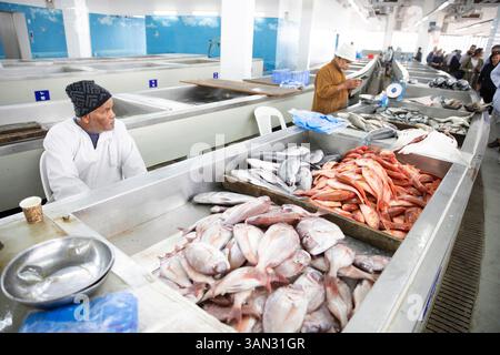 Mann, der Fisch auf dem Fischmarkt Mutrah in Maskat Oman in der Nähe des Suq verkauft Stockfoto