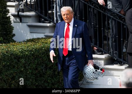 Washington, Usa. April 2025. Präsident Donald Trump hält einen Fußballhelm, als er am Montag, den 14. April 2025 auf dem Südrasen des Weißen Hauses in Washington D.C. eine Veranstaltung mit dem Gewinnerteam der College Football Championship 2025, der Ohio State University, abreist. (Foto: Aaron Schwartz/SIPA USA) Credit: SIPA USA/Alamy Live News Stockfoto