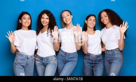 Fünf Multiethnische Frauen Winken Hand Lächelnd Posiert Auf Blauem Hintergrund Stockfoto