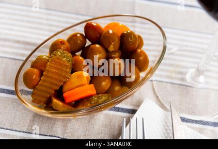 Grüne Oliven serviert mit Gurke, Karotte, Knoblauch und Zwiebeln Stockfoto