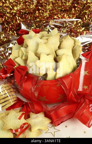 Köstliches, frisch gebackenes Weihnachtsgebäck in Cellophan und Weihnachtsdose Stockfoto