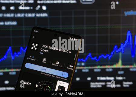 Dhaka, Bangladesch 08. März 2025: Installationsbildschirm der OKX-App auf einem Smartphone und die Finanzmarktkarte im Hintergrund Stockfoto