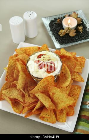 Nachos und mexikanischer Dip mit Sauerrahm, Salsa und geriebenem Käse Stockfoto