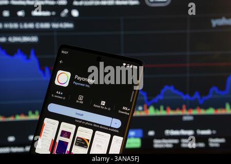Dhaka, Bangladesch 08. März 2025: Installationsbildschirm der Payoneer-App auf einem Smartphone und die Finanzmarktkarte im Hintergrund Stockfoto