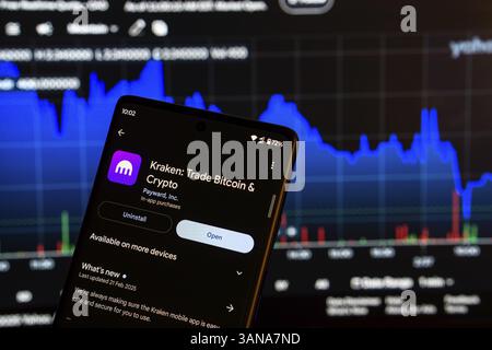 Dhaka, Bangladesch 08. März 2025: Installationsbildschirm der Kraken-App auf einem Smartphone und die Finanzmarktkarte im Hintergrund Stockfoto