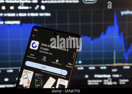Dhaka, Bangladesch 08. März 2025: Installationsbildschirm der Gate.io App auf einem Smartphone und die Finanzmarktkarte im Hintergrund Stockfoto